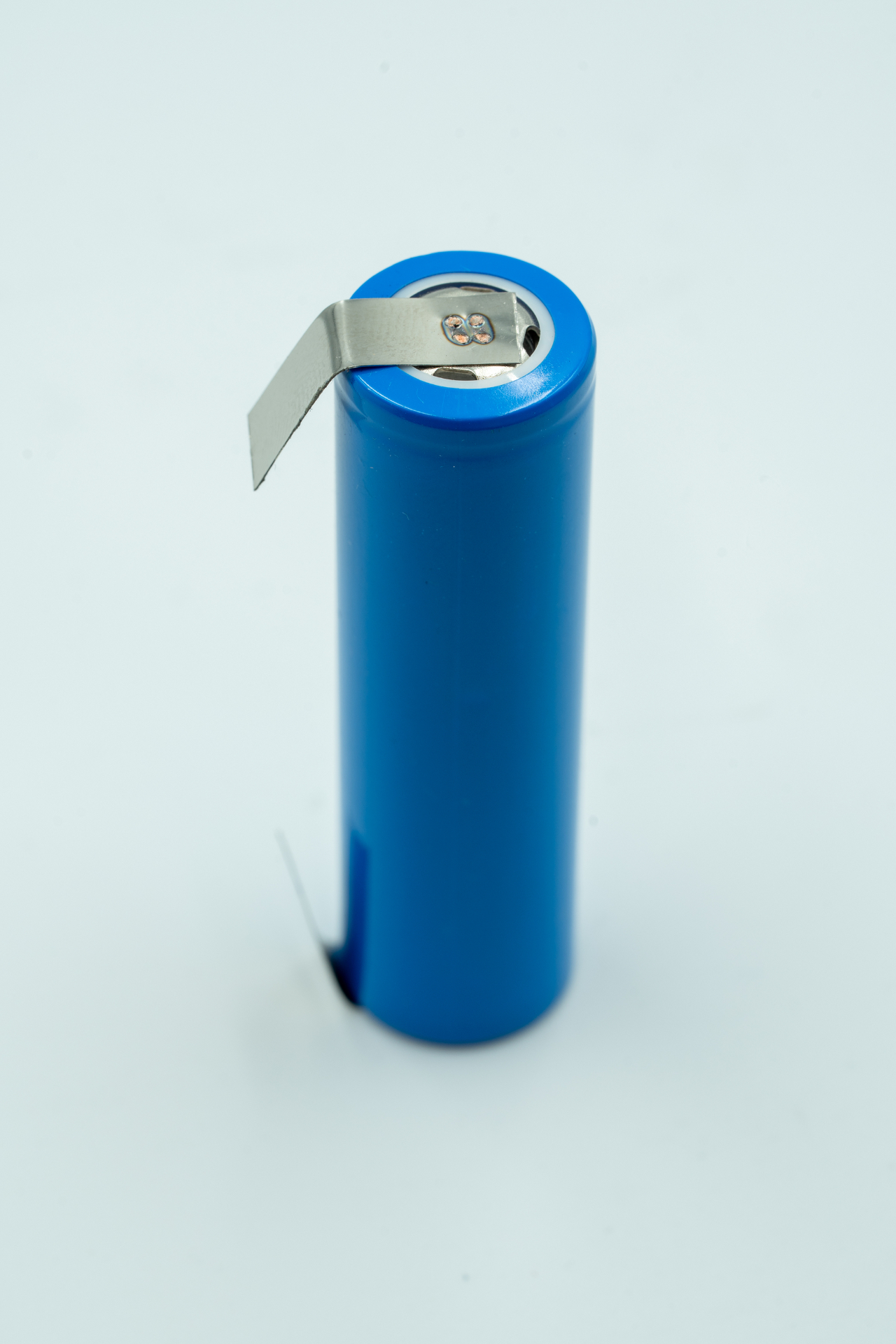Nickel tab gap-welded onto a Li-ion cell terminal — precise dual-electrode contact ensuring low resistance and mechanical strength.