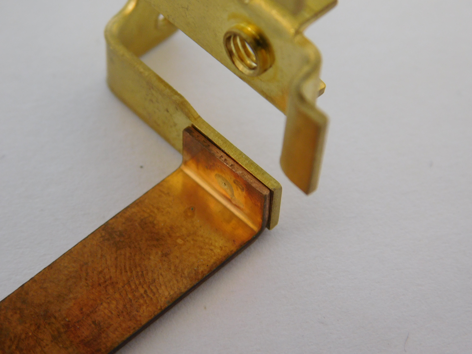 Brass terminal welded to a copper busbar — precision joint produced with a welding pincer for power distribution components.